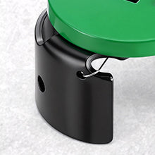 Close-up of a black metal component with a green circular object on a white background