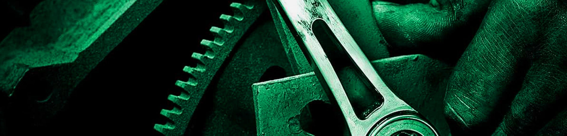 Close-up of a mechanical component with gears and a hand holding a tool, all in a green tint.